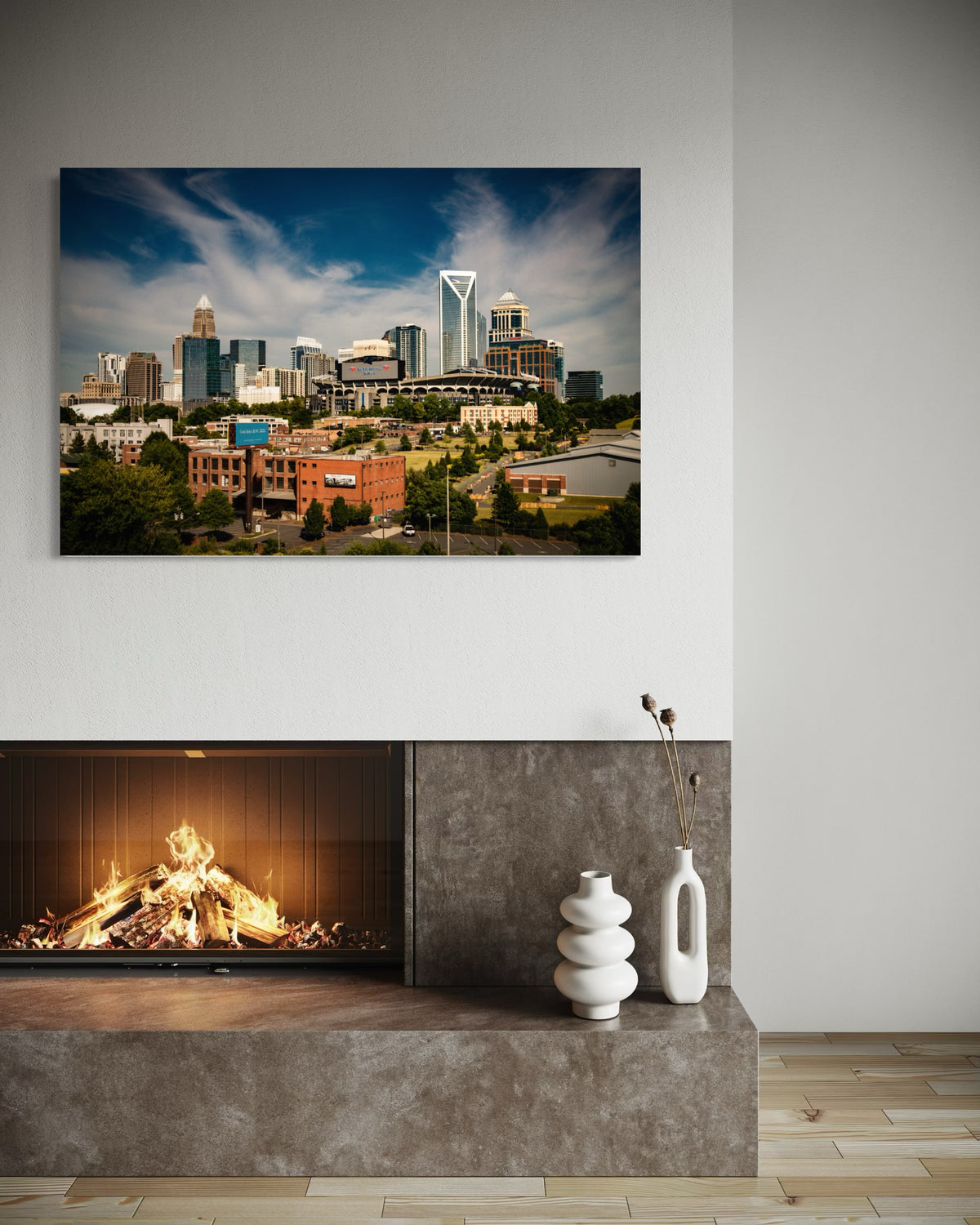 Queen City Charlotte skyline print above a modern fireplace with white ceramic vases