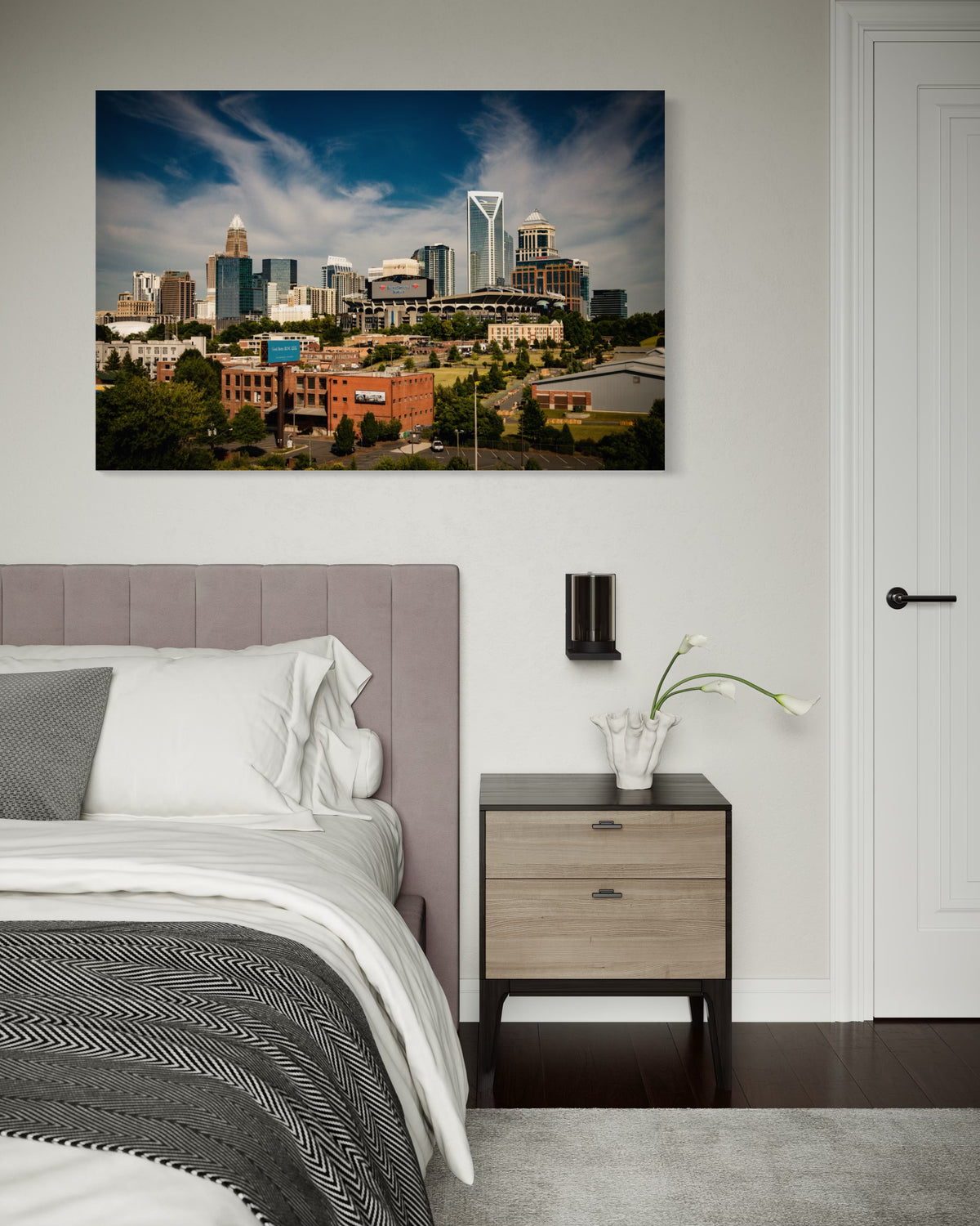 Queen City Charlotte skyline print above a bed and nightstand in a bedroom