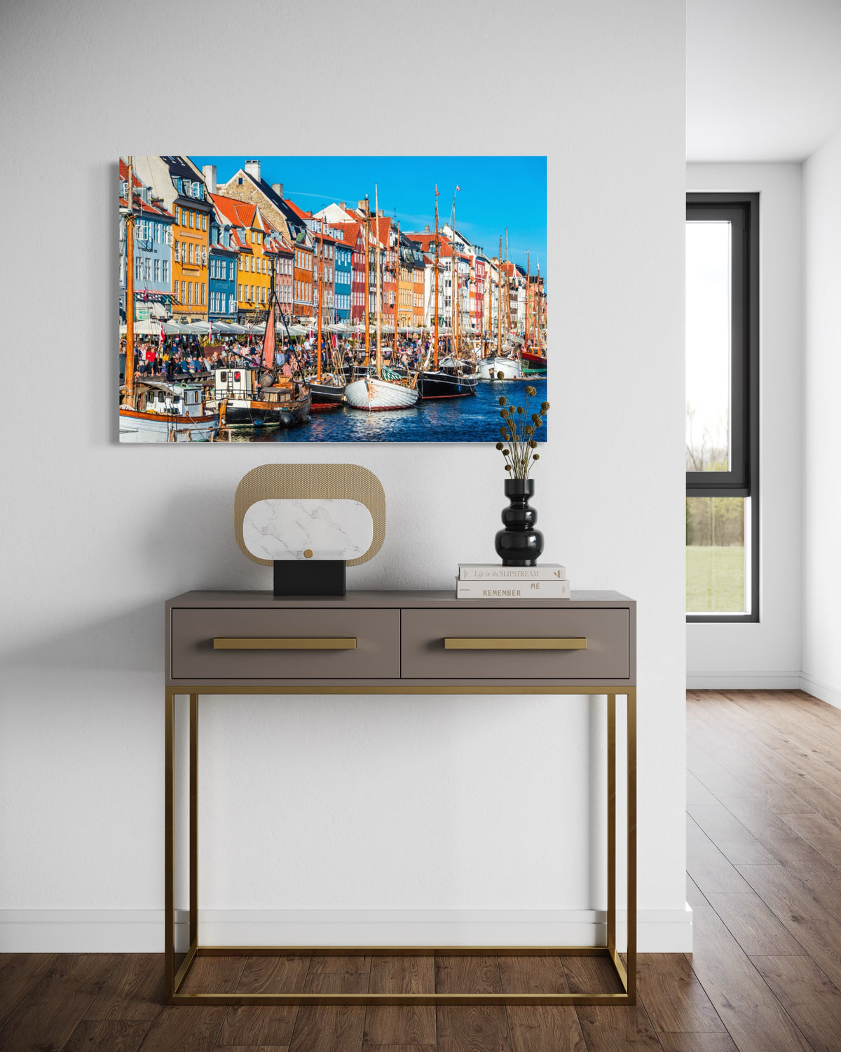 Nyhavn print above a taupe console table with gold legs in an entryway