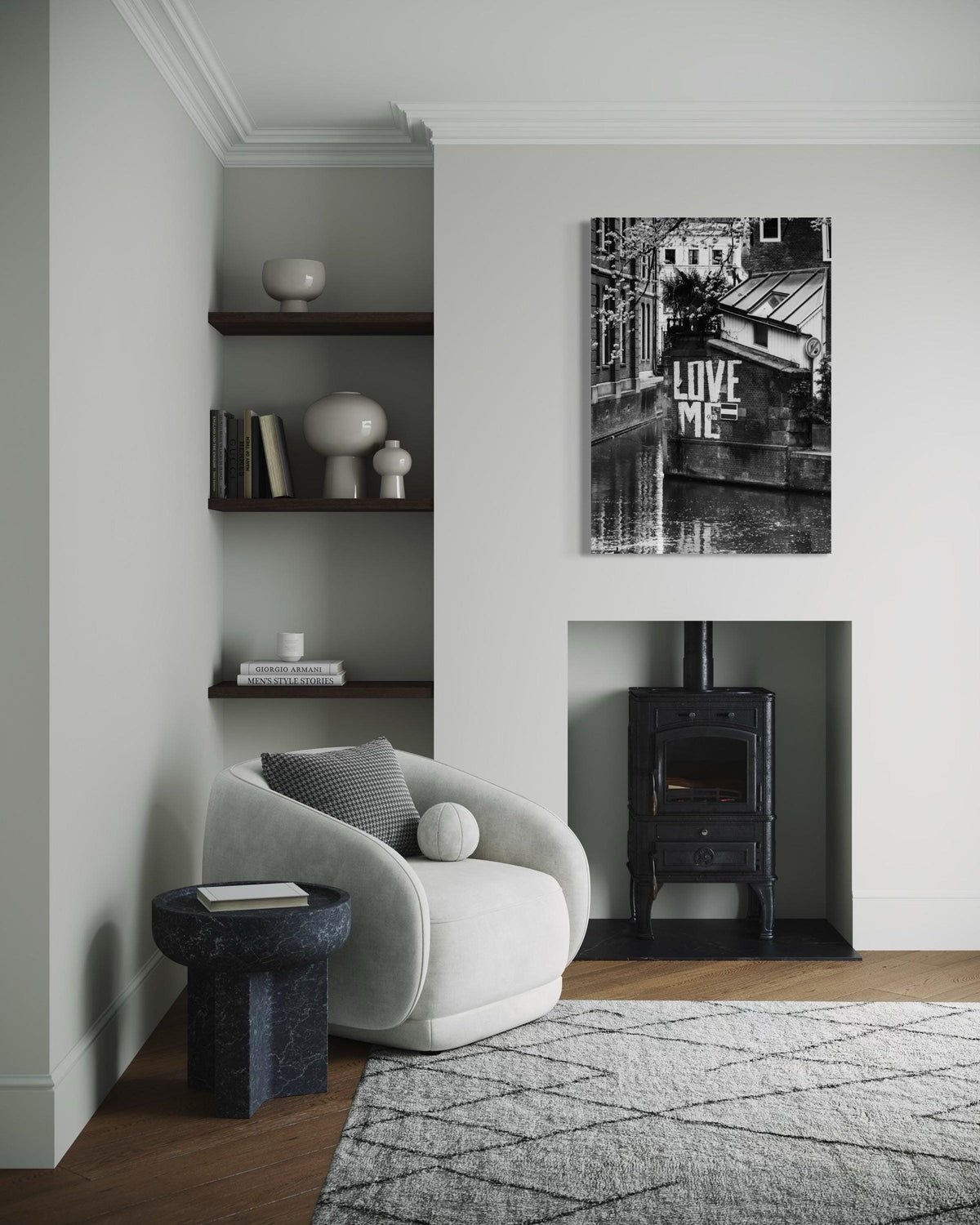 Love Me print above a black wood stove, beside a white armchair and recessed shelves