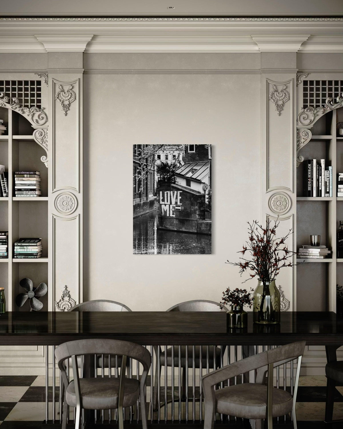 Love Me print on a wall between ornate built-in bookcases, above a dark dining table